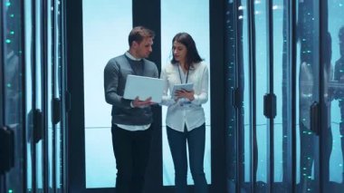 Modern bir veri merkezinde, iki yetenekli profesyonel derin bir tartışma ve veri analizi gerçekleştirir.