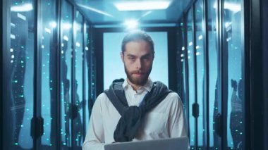 Kendini işine adamış ve işine odaklanmış bir işadamı ileri teknoloji ile dolu çağdaş bir veri merkezine ustaca yön veriyor.