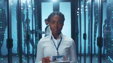 Bir veri merkezi içinde özenle çalışan odaklanmış bir birey, güvenlik protokolleri konusundaki uzmanlığını gösteriyor