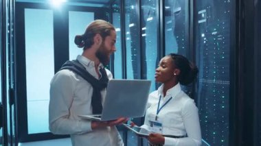 İki profesyonel, modern bir veri merkezinde takım çalışması ve teknoloji içeren bir tartışmaya giriştiler..