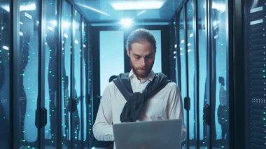 Bir bilişim uzmanı modern bir veri merkezinde gelişmiş teknolojileri kullanarak karmaşık sistemleri ustalıkla yönetir.