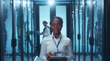 Çağdaş bir veri merkezi içinde ileri teknolojiyle ustaca etkileşim kuran usta bir teknisyen.