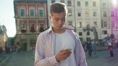 Ağır çekimde ciddi bir yüz. Sokakta duran ciddi bir adam. Telefonu kullan. Kameraya bak.