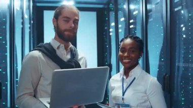 Bir grup profesyonel, bir yüksek teknoloji veri merkezi içinde etkin bir işbirliğine girişiyor.