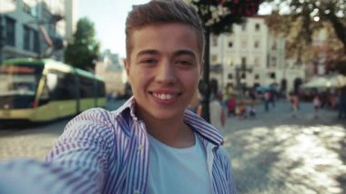 Mutlu genç adam, bak kamera şovu etrafında eski şehir gülümseme konuşması sokak çocuğu yavaş çekim yaşam tarzı Kafkasyalı neşeli çocuk yavaş çekim moda öğrencisi