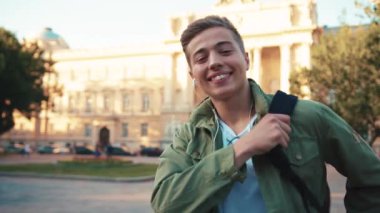 Kulaklık takmış genç bir portre. Kameraya bak. Gülümse. Sokakta mutlu ol.