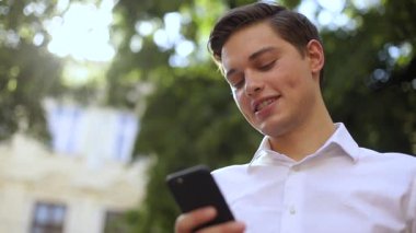 Mutlu yüz, başarılı iş adamı, şehirde gülümse, gülümse, bölge caddesi, mobil, Kafkas, şehir iş müdürü, açık hava teknolojisi, yürüyen, yakışıklı cep telefonu dokunmatik ekranı, aşağıdan.