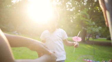 Küçük tatlı Afrikalı oyuncu kız atlıyor. Genç ve çekici bir baba kızını elinde tutuyor. Açık havada. Yaz zamanı. - Aile. Park et. Günlük yaşam.