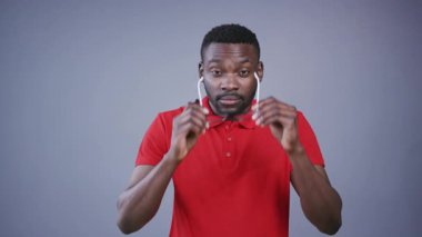 Çekici Afro-Amerikalı bir adamın ineği gözlük gibi takması ve gri arka planda büyüleyici bir şekilde gülümsemesi. İş adamı, yaratıcı süreç, beyin fırtınası, ofis. Erkek portresi