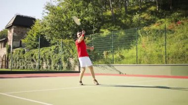 Çekici atletik sakallı genç adam başarılı bir şekilde tenis topunu atıyor ve oyunu kazanıyor, mutlu bir şekilde zıplıyor. Kazanan, zafer, yaşam sevinci. Erkek portresi
