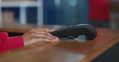 Postanedeki adam akıllı telefondan NFC başvurusu ile posta paketini ödüyor. Kadın operatör çek ve karton kutu veriyor..