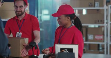 Kooperatif erkek ve kadın çiftlerden oluşan çok ırklı posta personeli müşterilere hizmet veriyor ve ofis departmanında çalışan karton kutular veriyor..