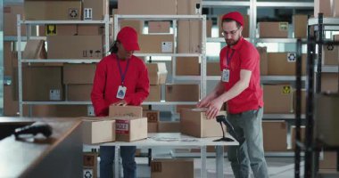 İşbirlikçi Çok Irklı Genç İşçi Çifti Kırmızı Profesyonel Üniformalı Paket Paket Paketleri Atölye İşbirliği Kutuları 'nda. Görev Konsepti.