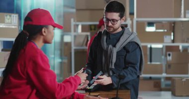 Kırmızı üniformalı çok ırklı iş arkadaşları çeşitli ofis atölyelerindeki müşterilere posta kutularını servis ediyorlar. Posta servisleri için kavram.