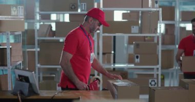 Birkaç Milenyum Kafkasyalı Kırmızı Üniformalı Karton Kutuları Postanede İşbirliği İçin Taşıyor ve Paketliyor.