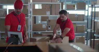 İki profesyonel Kafkasyalı işçi posta servisinde posta kutularını sınıflandırırken üniforma giyiyorlar. Takım çalışması. Ortaklık.