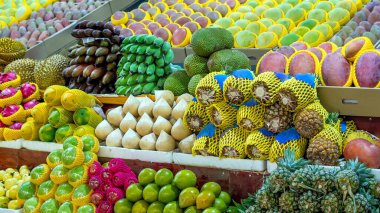 Egzotik tropikal meyveler bir market tezgahına serilir.