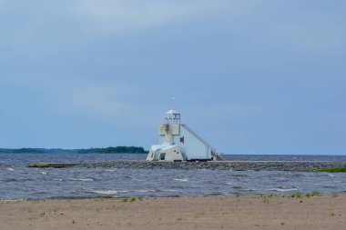 Lighthouse on the sandy beach of Nalikari in Oulu, Finland. The local landmark is also used as an observation tower for tourists. Early spring, cold, deserted clipart