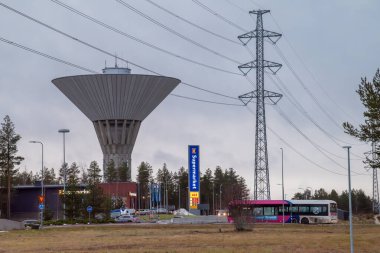 Oulu, Finlandiya - 30 Kasım 2024: Bulutlu bir sonbahar gününde şehir manzarası. Maikkula su kulesi. Yüksek voltaj güç hattı