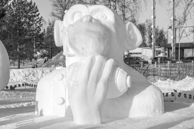 Oulu, Finlandiya, 15 Şubat 2025 Kar Heykeli Festivali. Savaş bombası ve elma tutan bir maymunun kar heykeli. Festivalin teması 