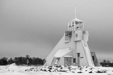 Finlandiya, Oulu. Bulutlu bir kış gününde Nallikari şehir plajında deniz feneri. Donmuş denizin manzarası.