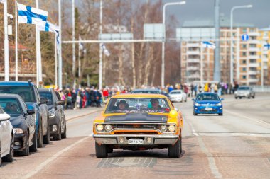 Retro araba. Fin bayrakları arka planda görünür. Geleneksel klasik eski araba şehir gezisi. Oulu, Finlandiya - 1 Mayıs 2025