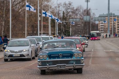 Retro araba. Fin bayrakları arka planda görünür. Geleneksel klasik eski araba şehir gezisi. Oulu, Finlandiya - 1 Mayıs 2025