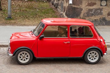 Mini 'nin caddede sürdüğü Retro Car. Geleneksel eski araba gezisi şehrin sokaklarında yapılıyor. Oulu, Finlandiya - 1 Mayıs 2025