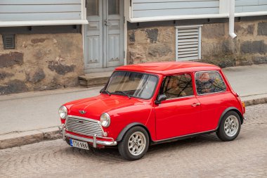Mini 'nin caddede sürdüğü Retro Car. Geleneksel eski araba gezisi şehrin sokaklarında yapılıyor. Oulu, Finlandiya - 1 Mayıs 2025