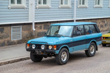 Retro araba Range Rover caddeden aşağı gidiyor. Geleneksel eski araba gezisi şehrin sokaklarında yapılıyor. Oulu, Finlandiya - 1 Mayıs 2025