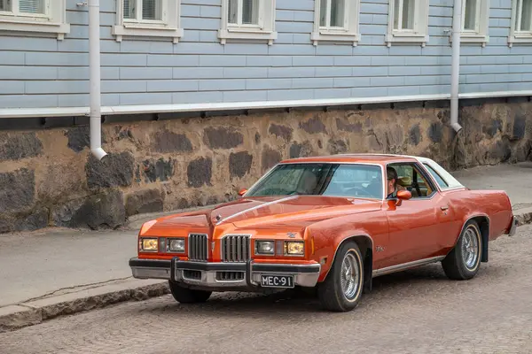 Retro araba caddeden aşağı gidiyor. Geleneksel eski araba gezisi şehrin sokaklarında yapılıyor. Oulu, Finlandiya - 1 Mayıs 2025