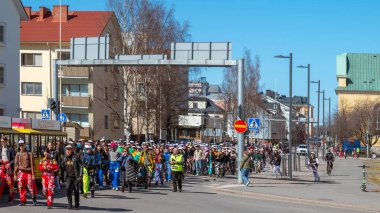 Mayıs Arifesi geleneksel bir öğrenci karnavalı günüdür. Öğrenciler liyakat uygulamaları ile renkli tulumlar giyerler. Şehrin sokaklarında şenlik yürüyüşü. Oulu, Finlandiya - 2025, 30 Nisan.