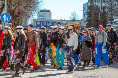 Mayıs Arifesi geleneksel bir öğrenci karnavalı günüdür. Öğrenciler liyakat uygulamaları ile renkli tulumlar giyerler. Şehrin sokaklarında şenlik yürüyüşü. Oulu, Finlandiya - 2025, 30 Nisan.