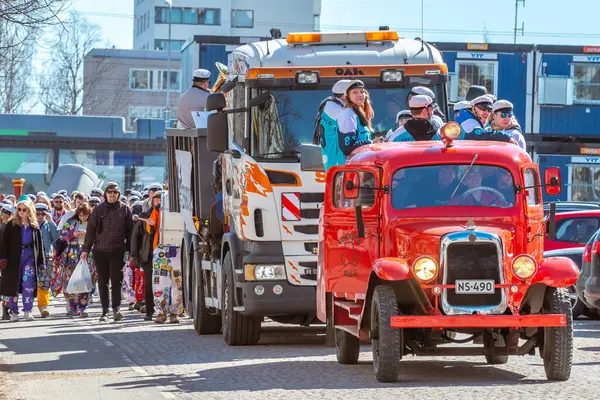 Mayıs Arifesi geleneksel bir öğrenci karnavalı günüdür. Kutlama sütununun başında, eski model kırmızı bir arabanın liderleri yer alıyor. Oulu, Finlandiya - 2025, 30 Nisan.