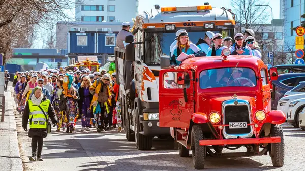 Mayıs Arifesi geleneksel bir öğrenci karnavalı günüdür. Kutlama sütununun başında, eski model kırmızı bir arabanın liderleri yer alıyor. Oulu, Finlandiya - 2025, 30 Nisan.