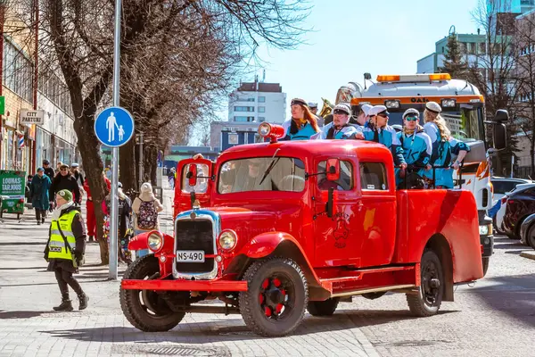 Mayıs Arifesi geleneksel bir öğrenci karnavalı günüdür. Kutlama sütununun başında, eski model kırmızı bir arabanın liderleri yer alıyor. Oulu, Finlandiya - 2025, 30 Nisan.