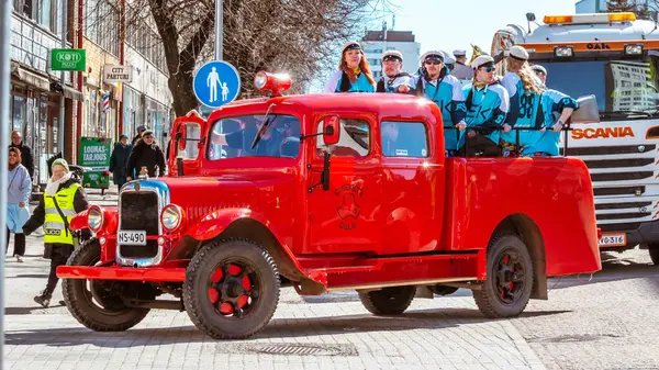 Mayıs Arifesi geleneksel bir öğrenci karnavalı günüdür. Kutlama sütununun başında, eski model kırmızı bir arabanın liderleri yer alıyor. Oulu, Finlandiya - 2025, 30 Nisan.