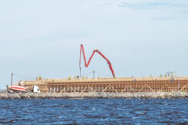 Finlandiya 'nın Hailuoto ve Oulunsalo adaları arasındaki en büyük köprüsünün inşaat sahasına beton dökülüyor. 2026 sonbaharında bir köprü olacak. Bu arada. Feribot burada çalışıyor..