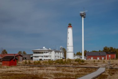 Finlandiya. 1871 'de Hailuoto adasında inşa edilmiş beyaz bir Marjaniemi deniz feneri. Yakınlarda deniz navigasyonu için modern bir radar sistemi var..