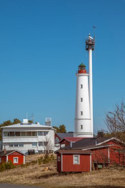 Finlandiya. 1871 'de Hailuoto adasında inşa edilmiş beyaz bir Marjaniemi deniz feneri. Yakınlarda deniz navigasyonu için modern bir radar sistemi var..