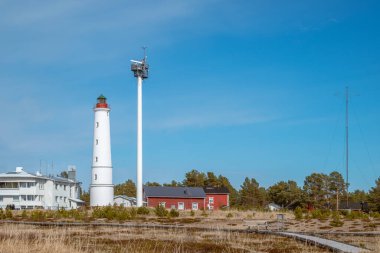 Finlandiya. 1871 'de Hailuoto adasında inşa edilmiş beyaz bir Marjaniemi deniz feneri. Yakınlarda deniz navigasyonu için modern bir radar sistemi var..