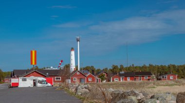 Finlandiya. 1871 'de Hailuoto adasında inşa edilmiş beyaz bir Marjaniemi deniz feneri. Yakınlarda deniz navigasyonu için modern bir radar sistemi var..