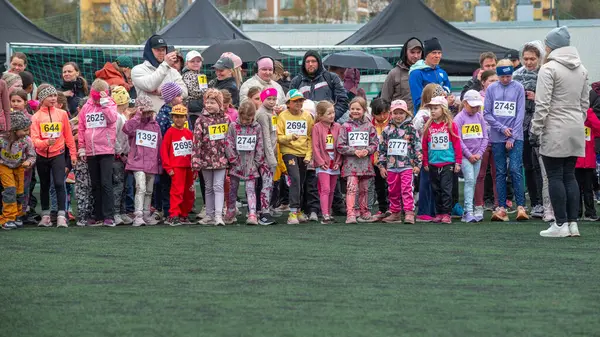Bir grup çocuk koşucu yarışı başlatmaya hazır. Küçük atletlerin ön eleme heyecanı. Hafif yağmur yağıyor. Oulu, Finlandiya - 2025, 23 Mayıs.