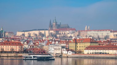 Prag Kalesi kompleksinin panoramik manzarası tarihi Küçük Şehir ve Vltava Nehri üzerinde yükseliyor. Tur teknesi. Prag, Çek Cumhuriyeti - 24 Şubat 2025.