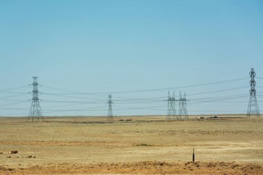 Endless electric line and towers in desert