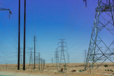 Endless electric line and towers in desert