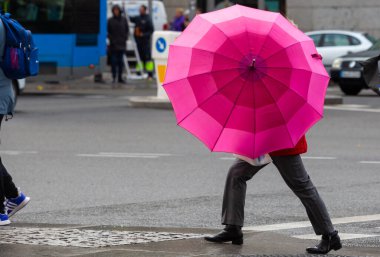 Madrid, İspanya - 24 Kasım 2022 Madrid 'de yağmurlu ve rüzgârlı istikrarsız hava. Yağmurlu bir günde şemsiyeli insanlar. Yağmurlu bir gün. Rüzgarlı ve yağmurlu bir gün. Sonbahar soğuğu.