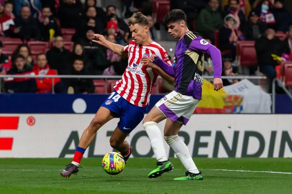 Madrid, Spain- January 21, 2023: Soccer match between Atletico de Madrid and Real Valladolid at Civitas Metropolitano. Marcos Llorente fights for the ball with an opponent.