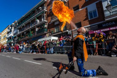 Madrid, Spain- January 21, 2023: Parade to celebrate the Chinese New Year through the streets of Madrid. Bonfire man releases fire from the mouth at the new year parade.