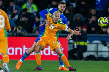Madrid, Spain- January 28, 2023: Soccer match between Real Betis balonpie and Getafe F.C in Madrid. The Betis player Sergio Canales fights with an opponent for the ball.